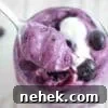 35 High-Protein Vegan Powder Recipes for Smoothies & Snacks 29 Blueberry protein fluff in a glass topped with coconut milk.