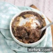 35 High-Protein Vegan Powder Recipes for Smoothies & Snacks 4 Chocolate protein mug cake topped with peanut butter and coconut whipped cream in a white mug.