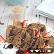 35 High-Protein Vegan Powder Recipes for Smoothies & Snacks 5 Chocolate protein French toast on a white plate drizzled with chocolate and strawberries.