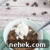 35 High-Protein Vegan Powder Recipes for Smoothies & Snacks 6 Chocolate brownie with chocolate chips in a white ramekin with whipped cream on top.