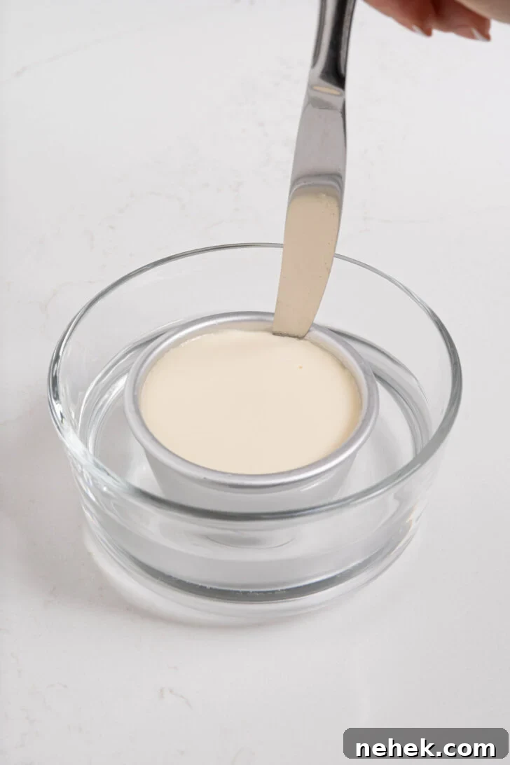 Panna cotta being loosened in a bowl.