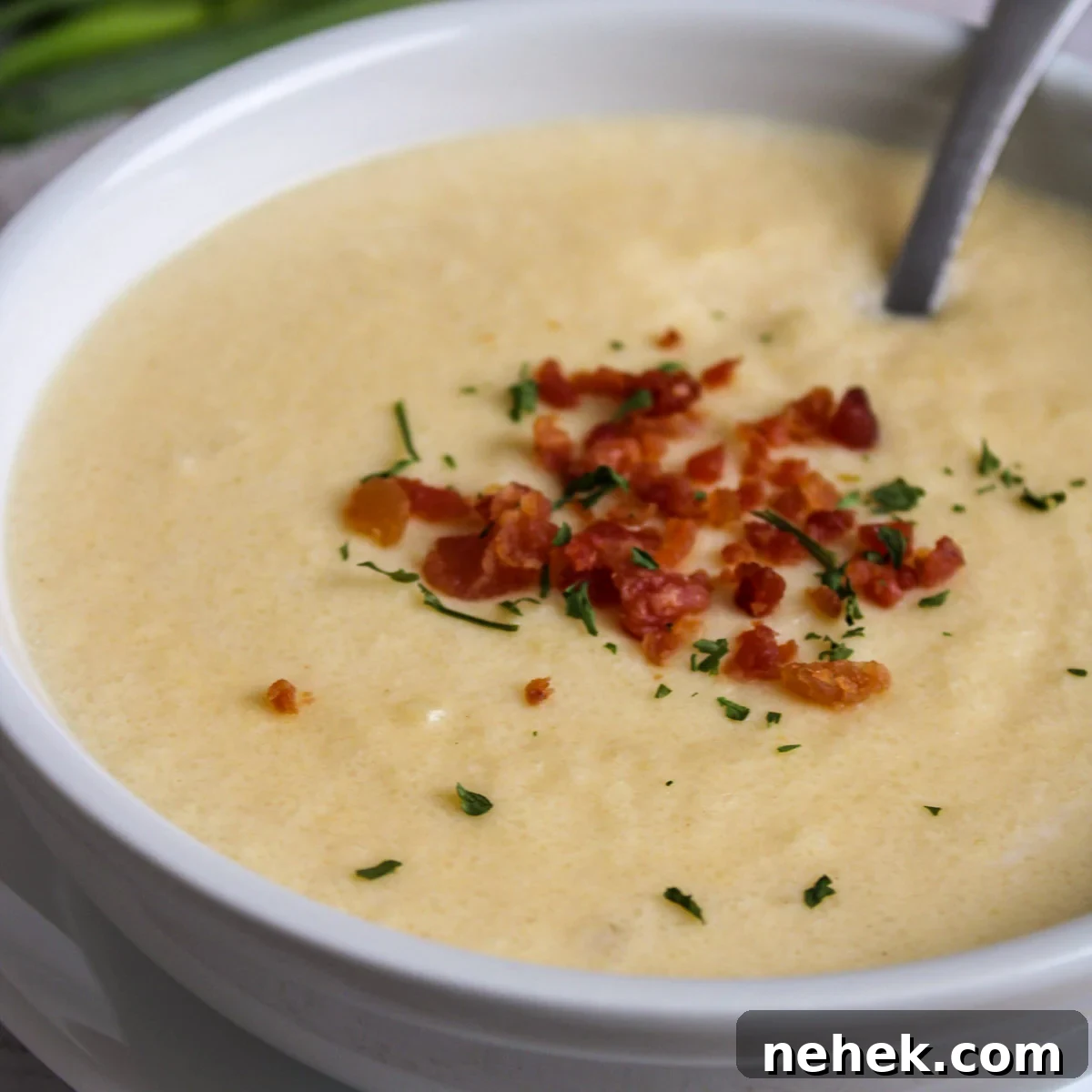 Garnished Cheesy Cauliflower soup in a bowl.
