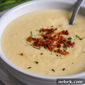 Garnished Cheesy Cauliflower soup in a bowl.