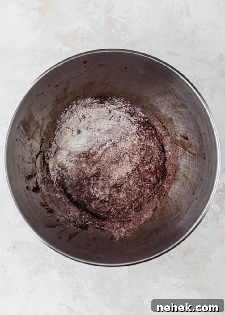A silver bowl of flour and cocoa powder on a beige table.
