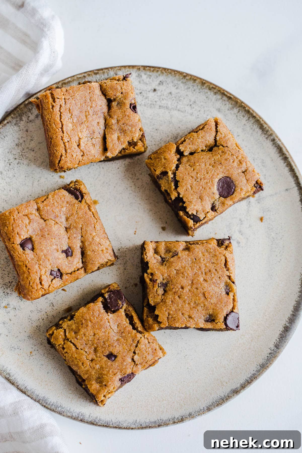 Gluten-Free Pumpkin Chocolate Chip Blondies — Fall Dessert Recipe 2 Blondies with chocolate chips on a plate.