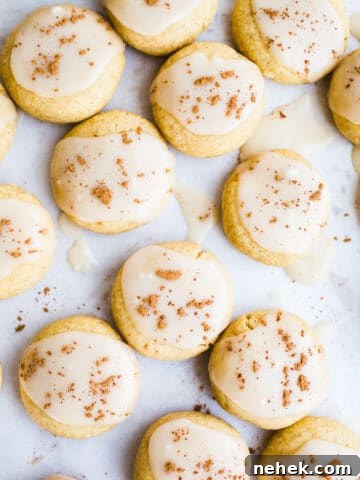 Soft pumpkin cookies with icing on a piece of parchment paper.