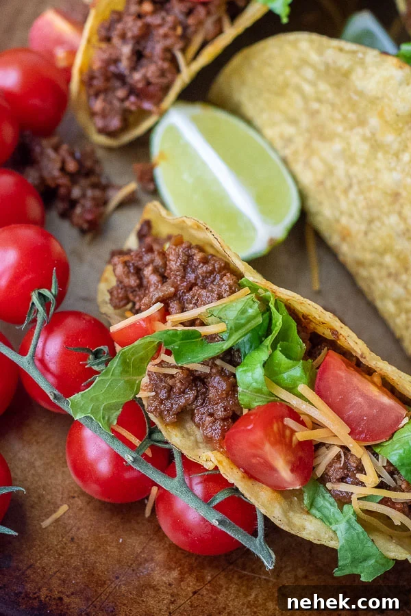 Sweet and Spicy Sloppy Joe Tacos with Lime Sour Cream 2 close up of beef taco with tomatoes, cheese, and lettuce