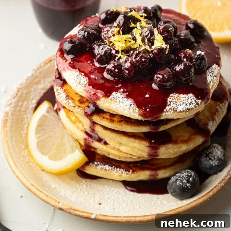 A top-down view of a pancake stack covered in blueberry compote