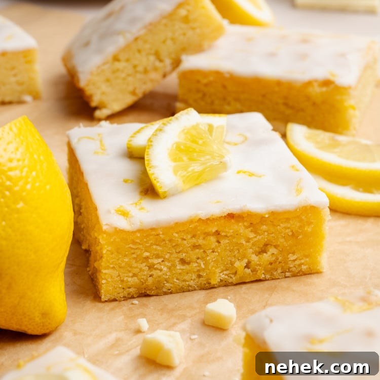 Lemon brownie square garnished with lemon wedges and lemon zest.