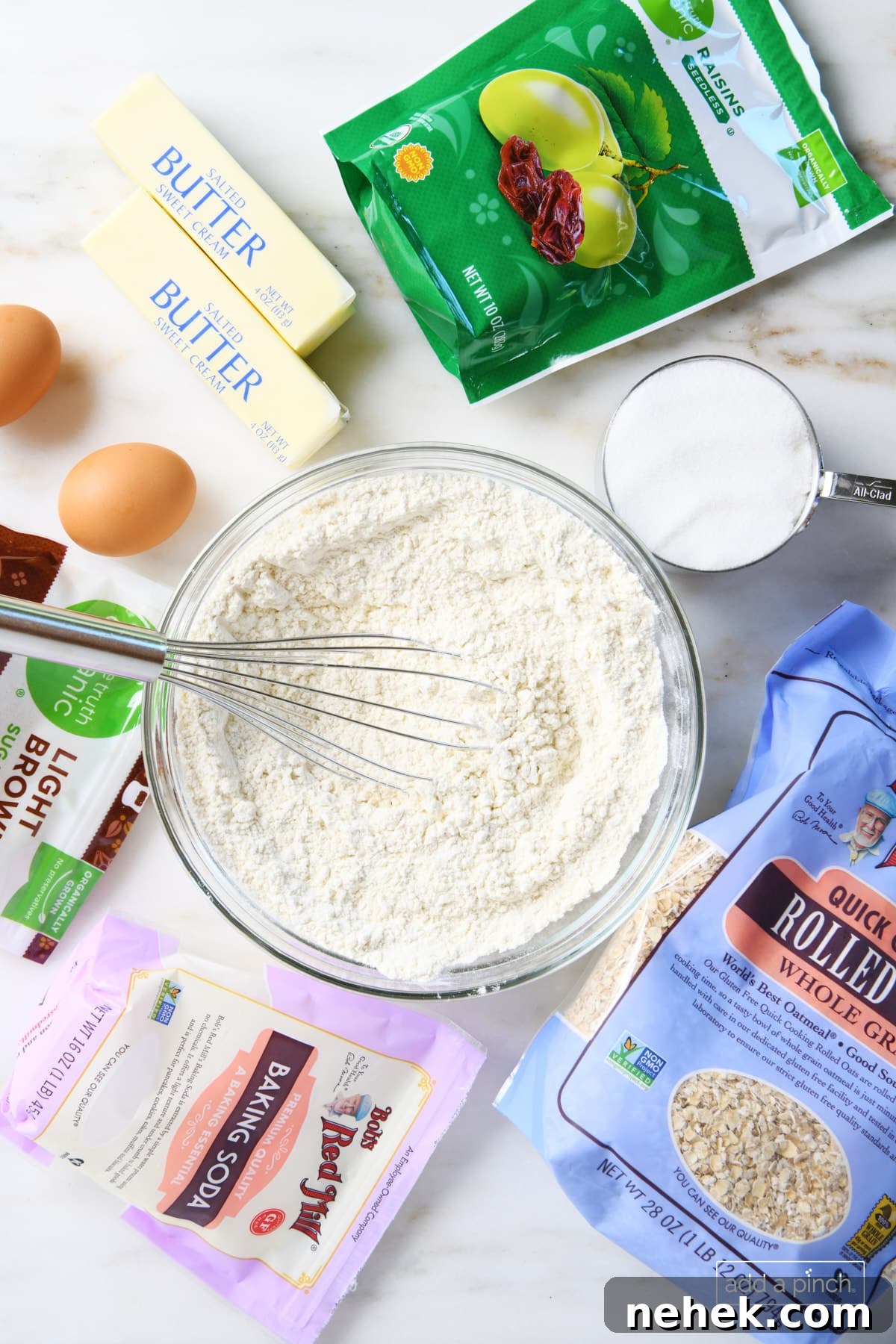 Ingredients for Oatmeal Raisin Cookies, like flour, brown and granulated sugars, butter, eggs, quick cooking rolled oats, raisins, salt and vanilla.