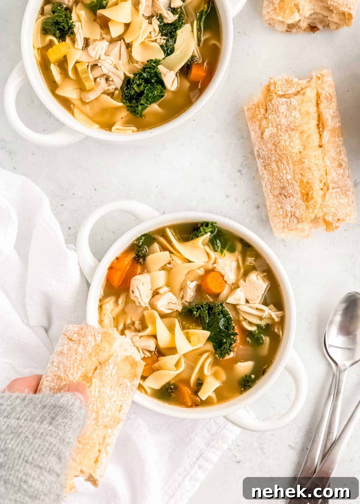 Classic Homemade Chicken Noodle Soup Recipe for Comforting Meals 10 crusty bread dipping into a bowl of simple chicken noodle soup with egg noodles