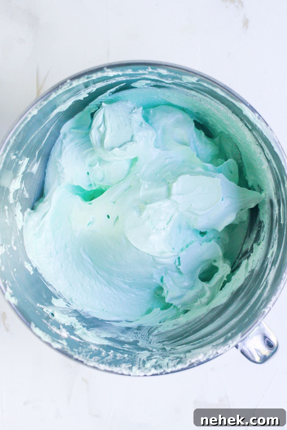 Meringue Christmas Tree Cookies: Festive Dessert Recipe Ideas 5 Green coloring and vanilla extract added to meringue in a silver bowl.