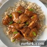 overhead shot of teriyaki chicken served over white rice garnished with green onion and sesame seeds