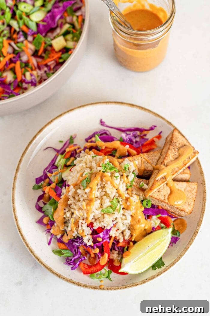 Plate of Thai chopped salad with rice, fresh veggies, tofu and peanut sauce.