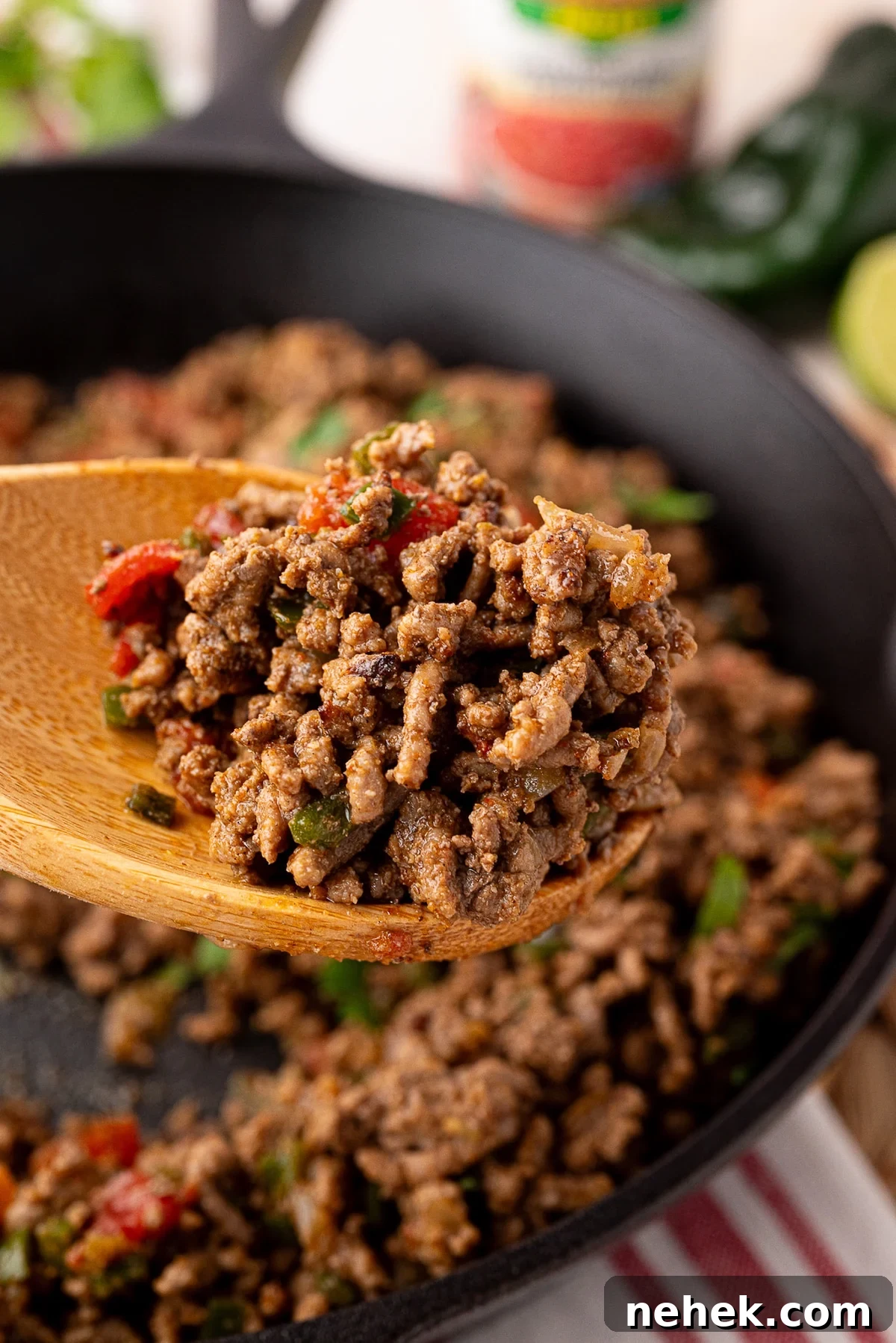 Flavorful Ground Beef Taco Meat Recipe for Tacos & Bowls 3 savory ground beef taco meat cooked in cast iron on a wooden spoon