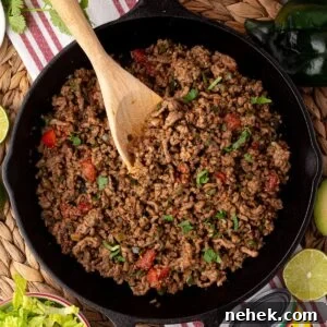 Flavorful Ground Beef Taco Meat Recipe for Tacos & Bowls 8 beef taco meat in skillet with visible tomato and cilantro garnish