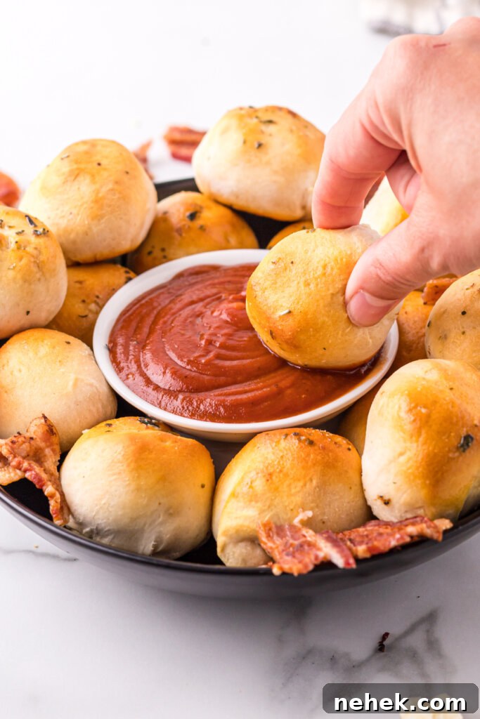 bacon bomb being dipped into pizza sauce