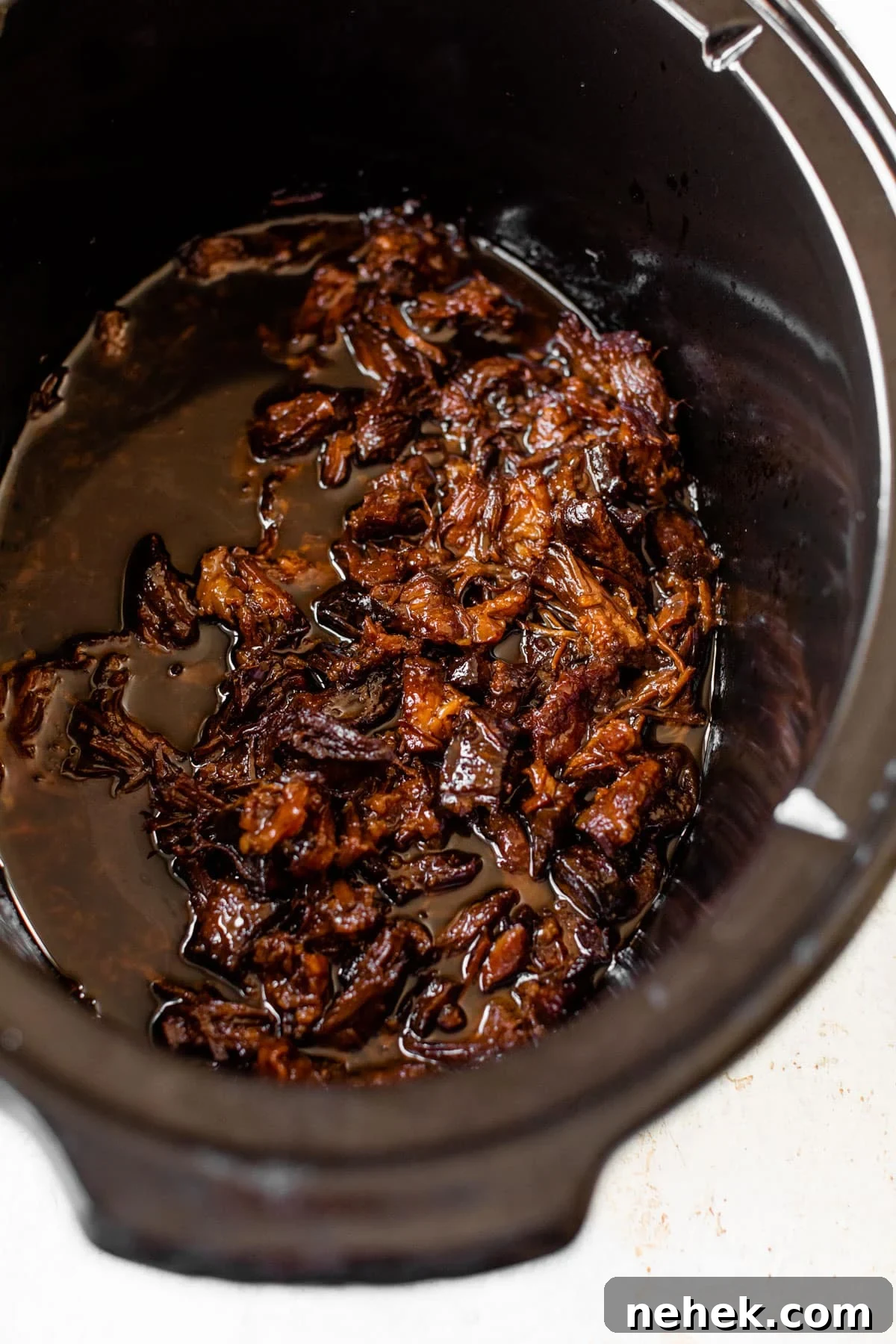 slow cooker filled with marinated pulled pork