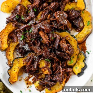 a platter of roasted acorn squash topped with marinated pulled pork