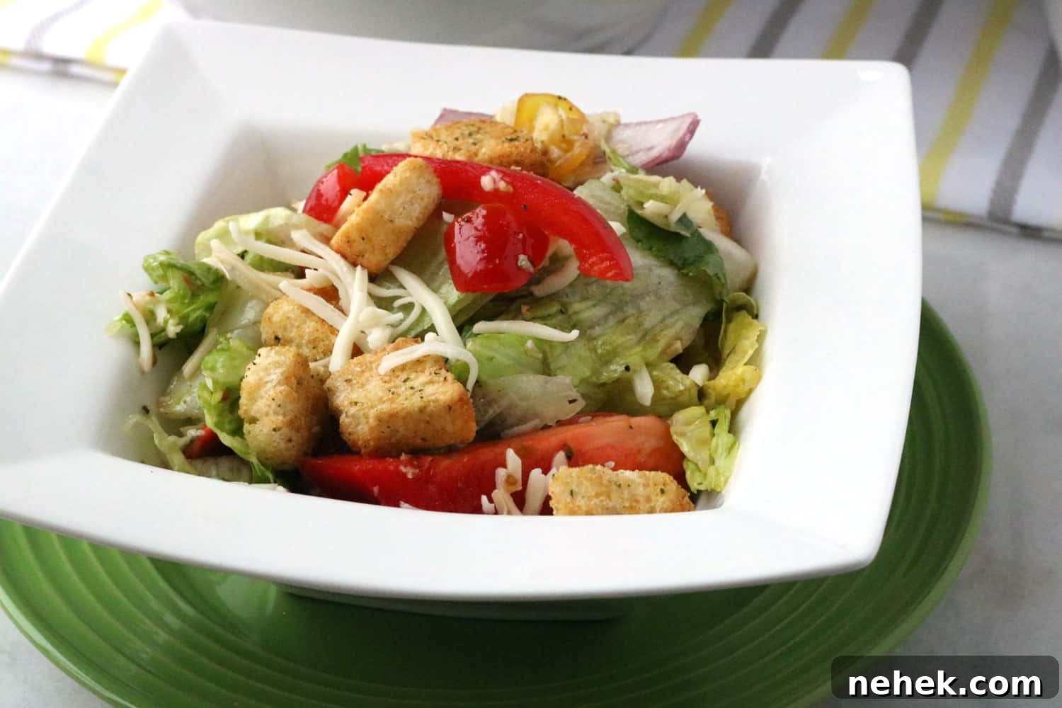 Classic Italian Salad with Homemade Dressing Recipe 2 Italian Salad with Homemade Dressing served in a white bowl on top of a green plate.