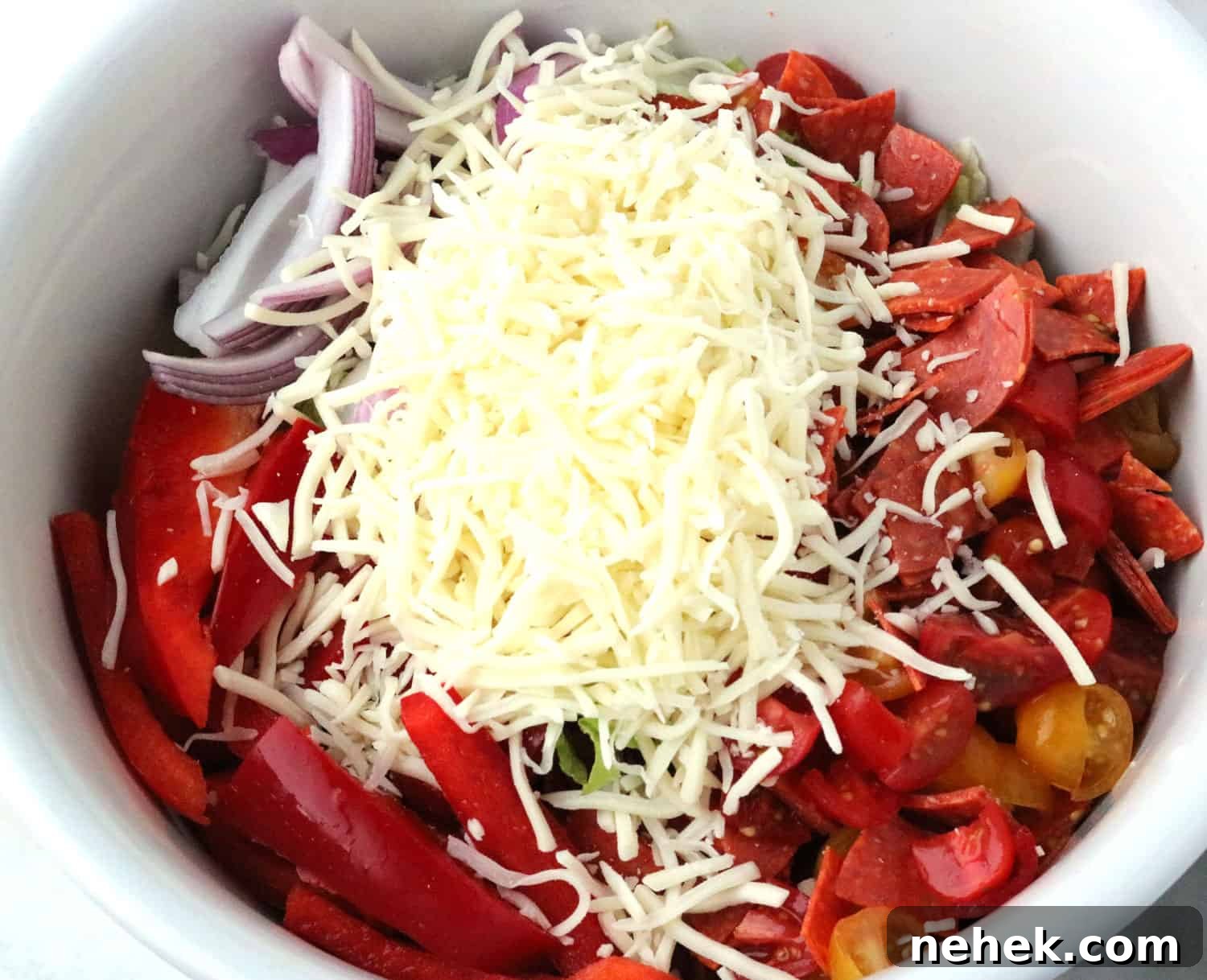 Classic Italian Salad with Homemade Dressing Recipe 4 All of the Italian salad ingredients combined in a large white bowl.