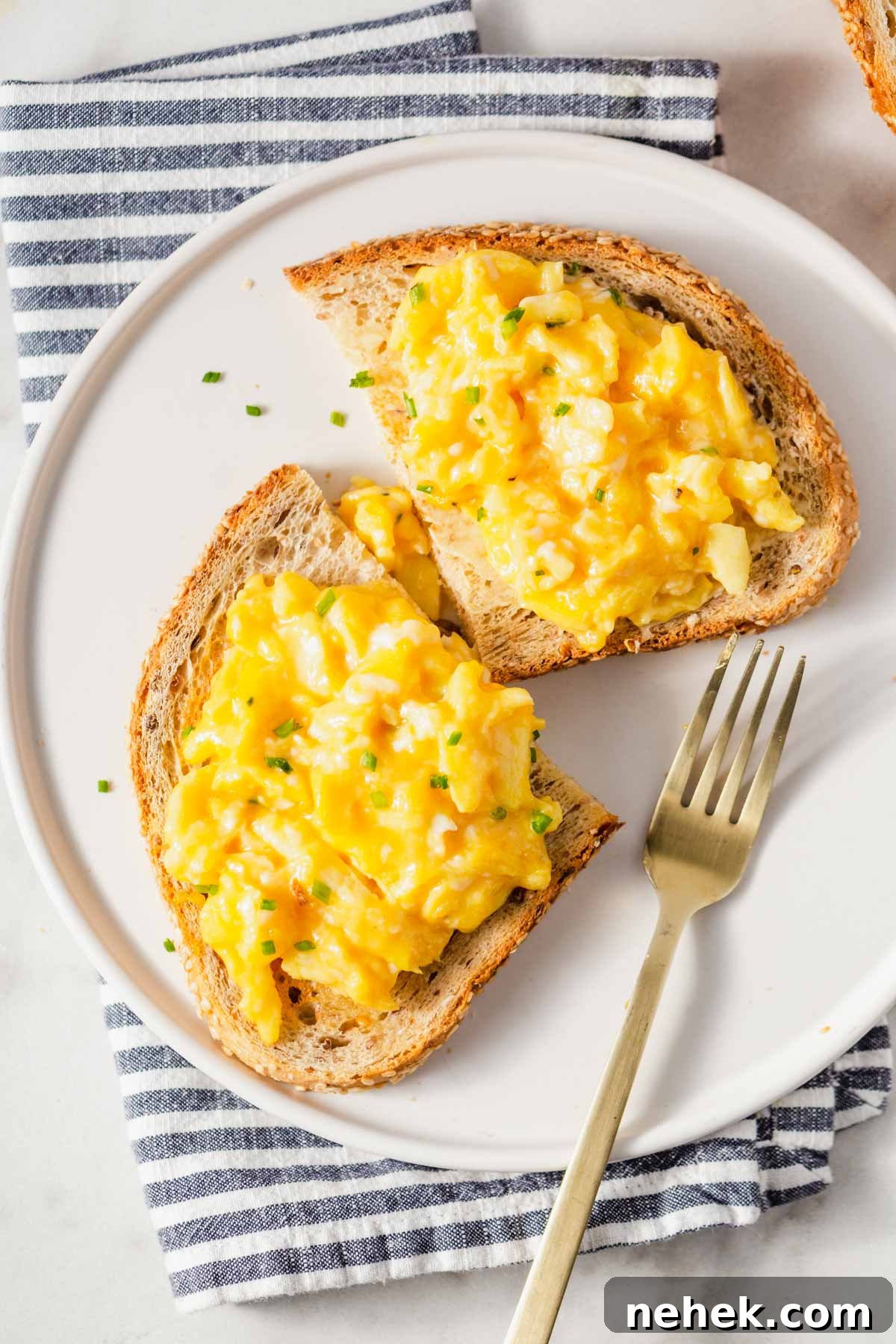 air fryer scrambled eggs on toast with fork on the side.