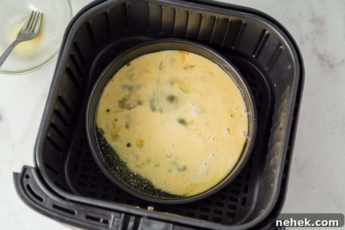 adding the egg mixture to the pan in the air fryer.
