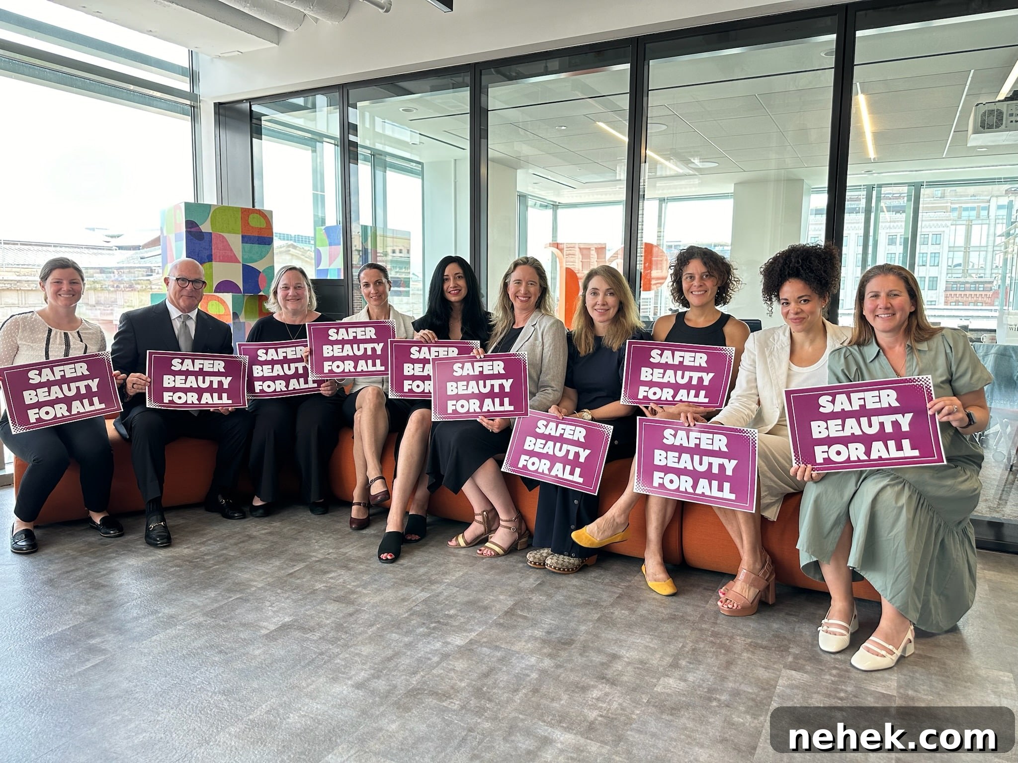 Support Safer Beauty: Back the Five Cosmetic Safety Bills Today 2 Team of people sitting, smiling at the camera holding signs that say 'Safe Beauty For All'
