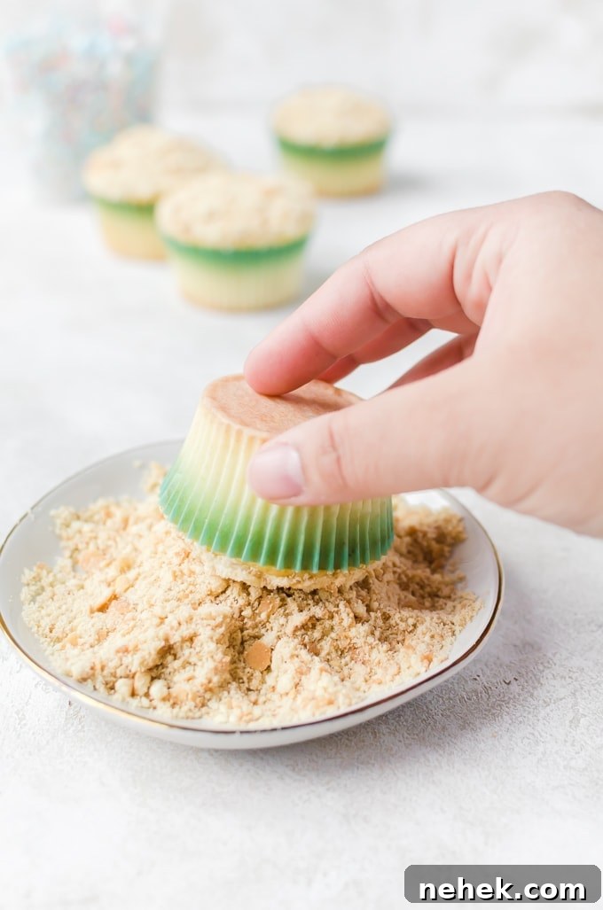 Mermaid cupcake dipped into crushed Nila wafers on a plate to make edible sand