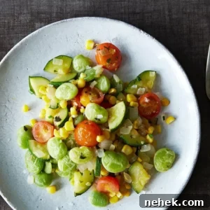 vegan summer succotash on a white plate next to a silver fork