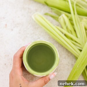 a hand holding a cup of corn silk tea