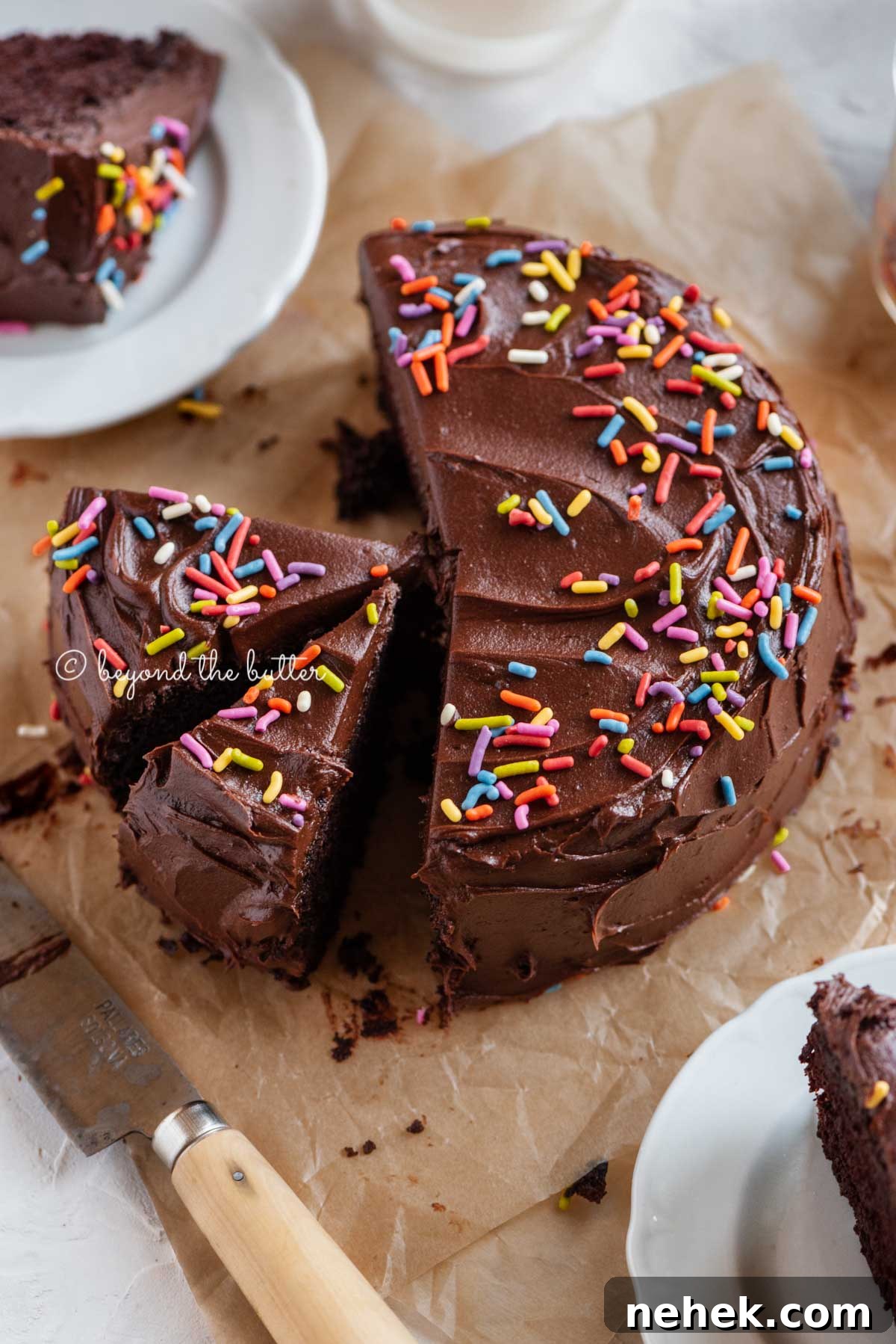 Quick Single-Layer Chocolate Cake Recipe for Perfect Moistness 2 Angled image of sliced single layer chocolate cake on parchment paper | All Images © Beyond the Butter™