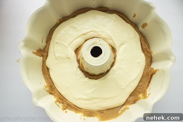 Cream cheese filling layer added over the top of pumpkin cake layer.