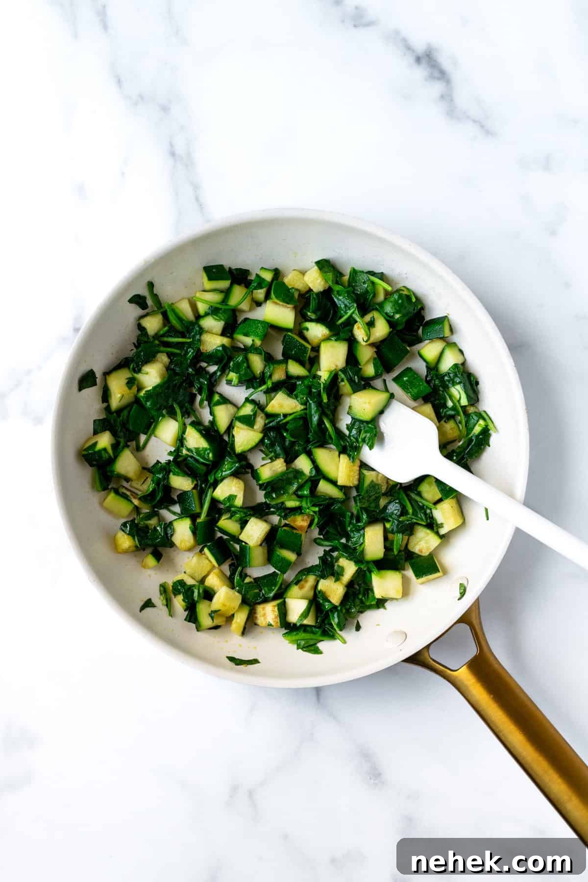 Cheesy Vegetable Baked Ziti with Roasted Tomatoes and Spinach 6 Sautéed Zucchini and Spinach in a white skillet.