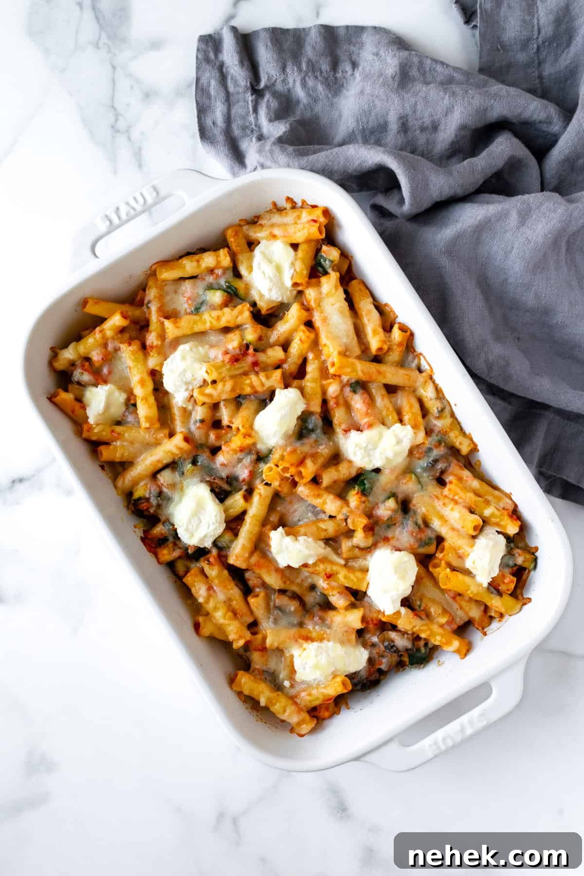 Cheesy Vegetable Baked Ziti with Roasted Tomatoes and Spinach 8 Vegetable Baked Ziti with Ricotta in a white baking dish.