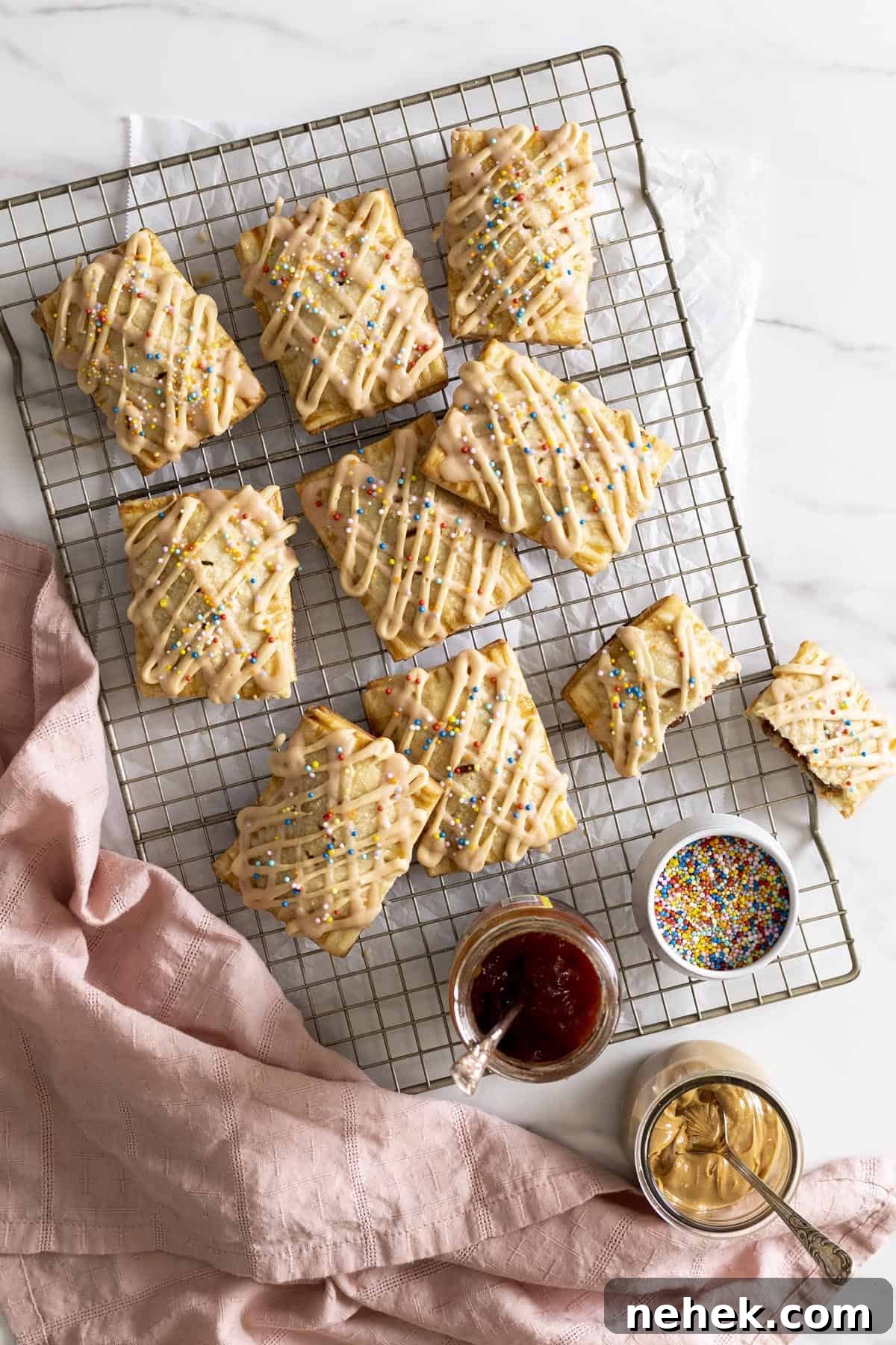 Peanut butter and jelly pop tarts on a wire rack next to a pink towel.