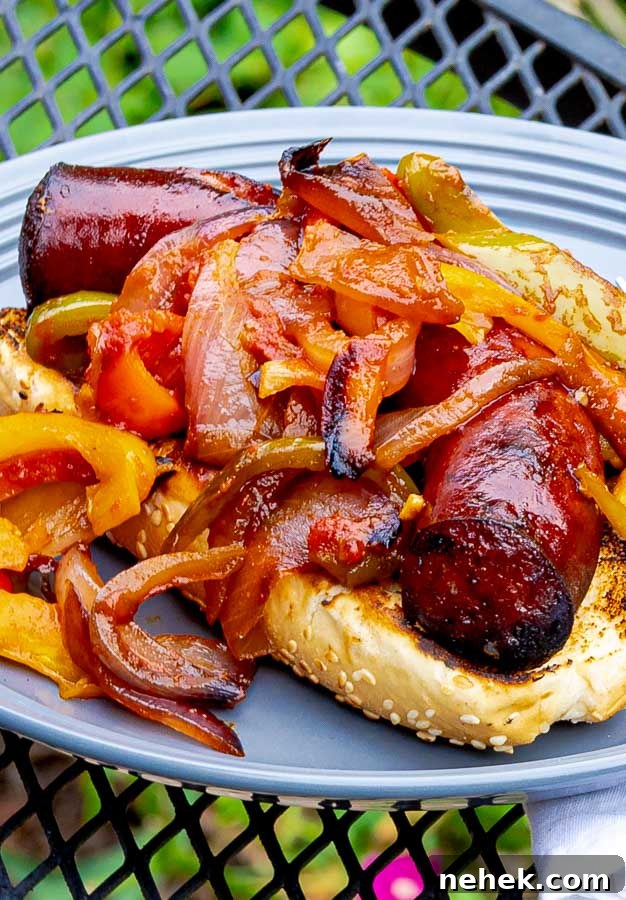 Grilled Sausage with Peppers and Onions on a bun on a gray plate
