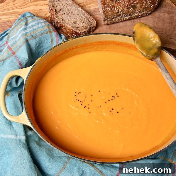Creamy Spiced Pumpkin Soup Made with Canned Pumpkin 5 Puréed carrot and sweet potato soup in a Dutch oven on a table.