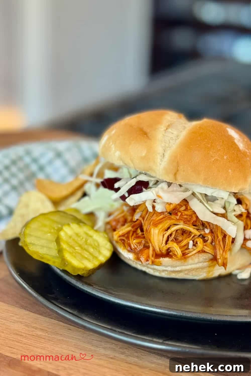 Slow-Cooker BBQ Shredded Chicken Sandwiches Recipe 3 BBQ shredded chicken sandwich topped with cabbage slaw, served with pickles and chips on a black plate