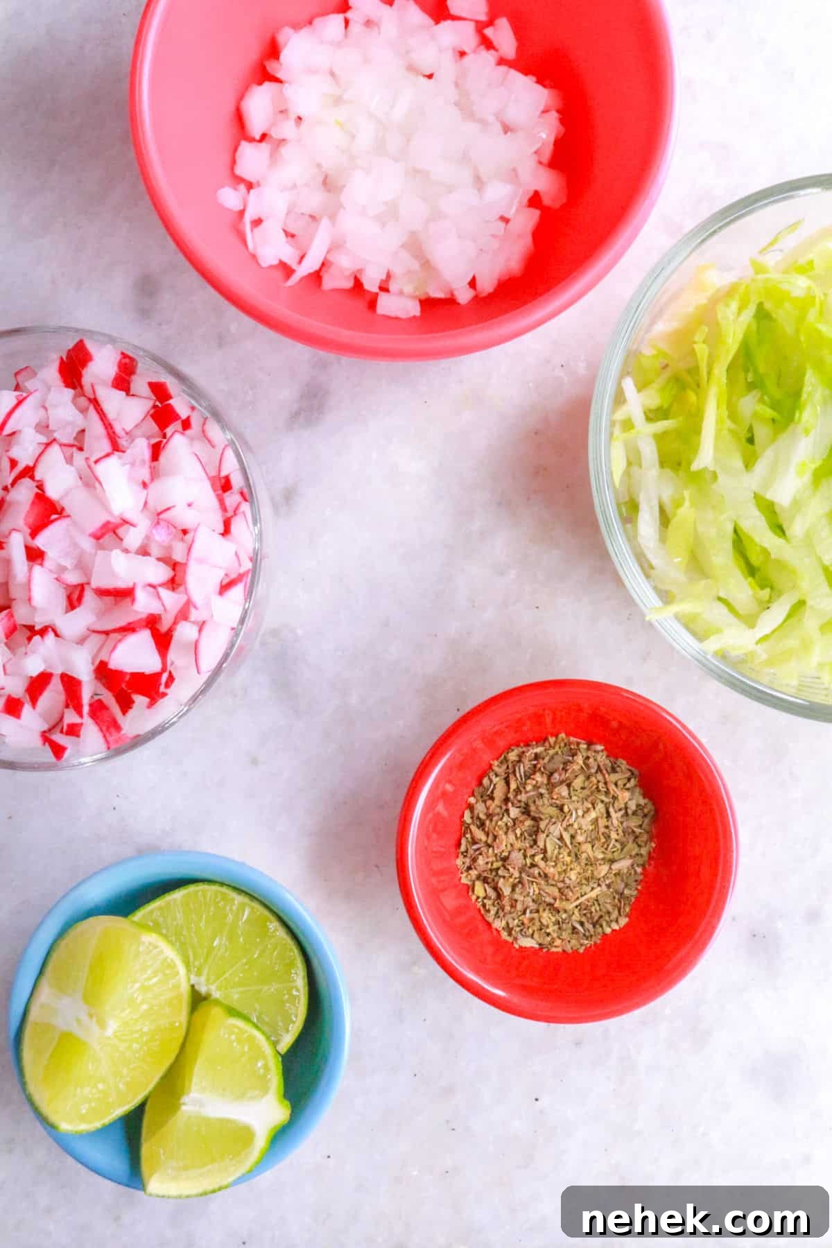 Garnishes for pozole: diced onion, diced radishes, shredded lettuce, oregano, limes
