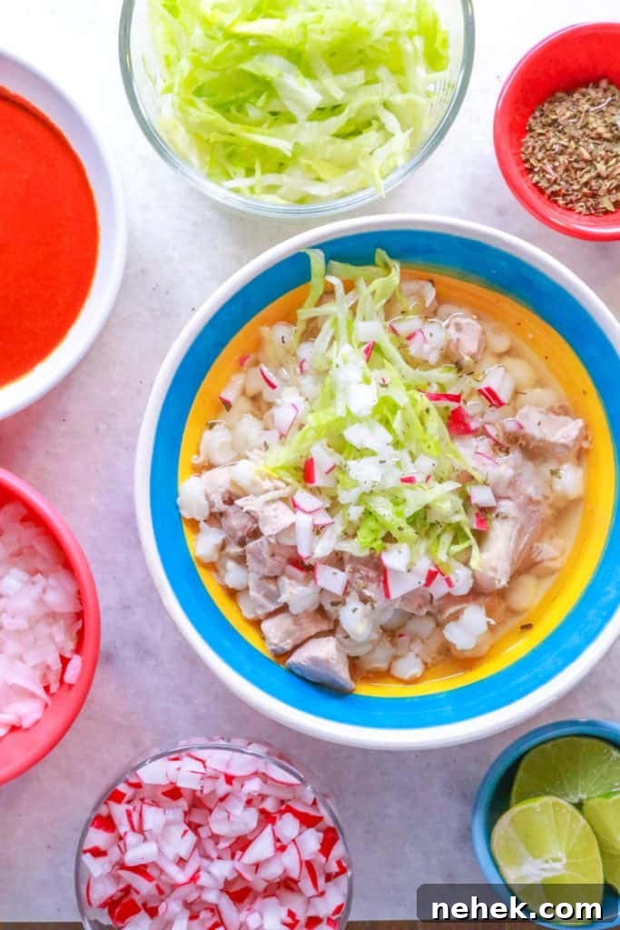 Bowl of Pozole Blanco with garnishes surrounded by small bowls with various garnishes