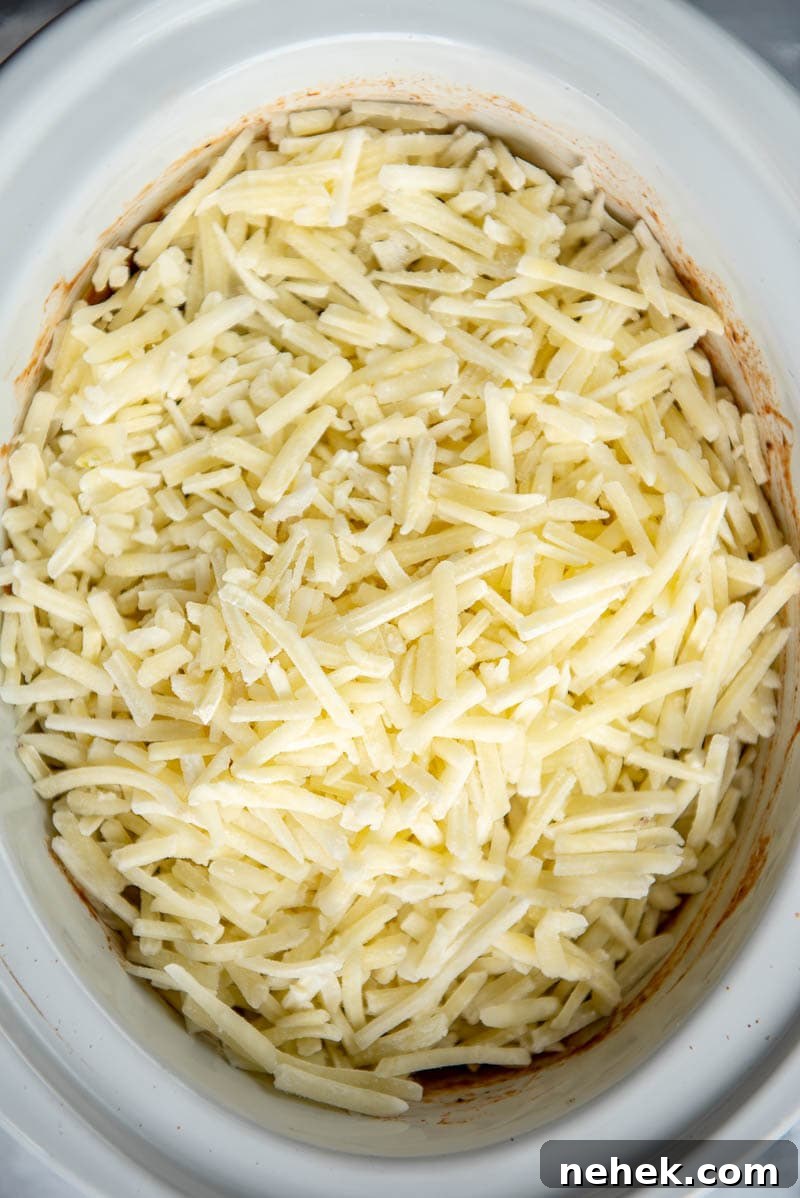 hashbrowns on sloppy joe mixture in a slow cooker