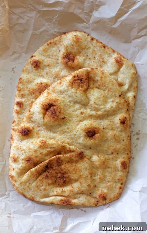 Crispy Potato Flatbread Recipe: Step-by-Step Homemade Guide 3 Photo of two pieces of naan bread on parchment paper.