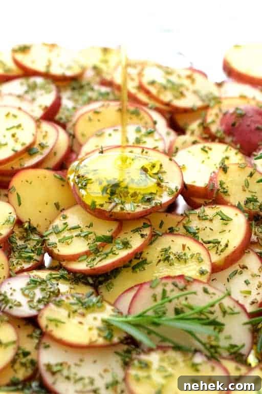 Crispy Potato Flatbread Recipe: Step-by-Step Homemade Guide 4 Photo of thinly sliced red potatoes sprinkled with rosemary being drizzled with olive oil.
