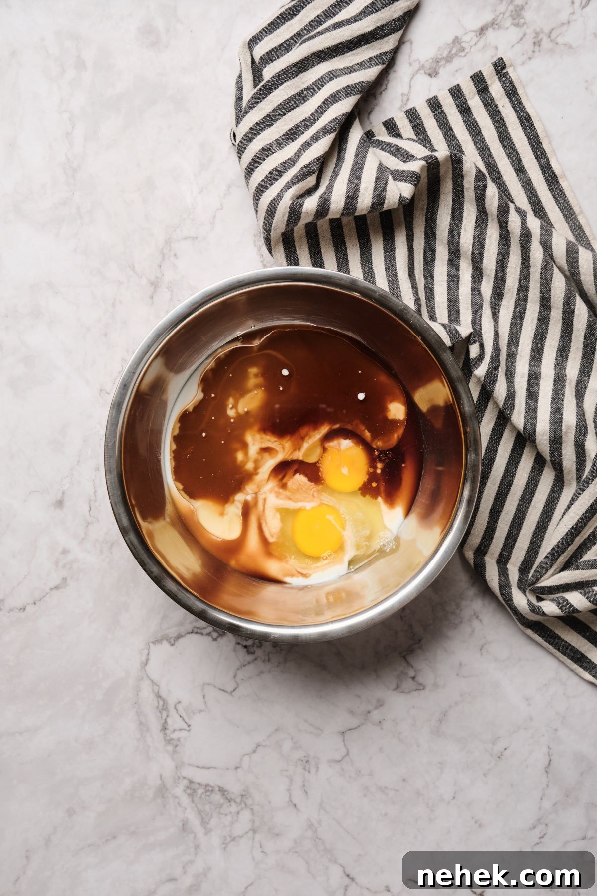 mixing sugar and wet ingredients in a mixing bowl for the two bowl method.