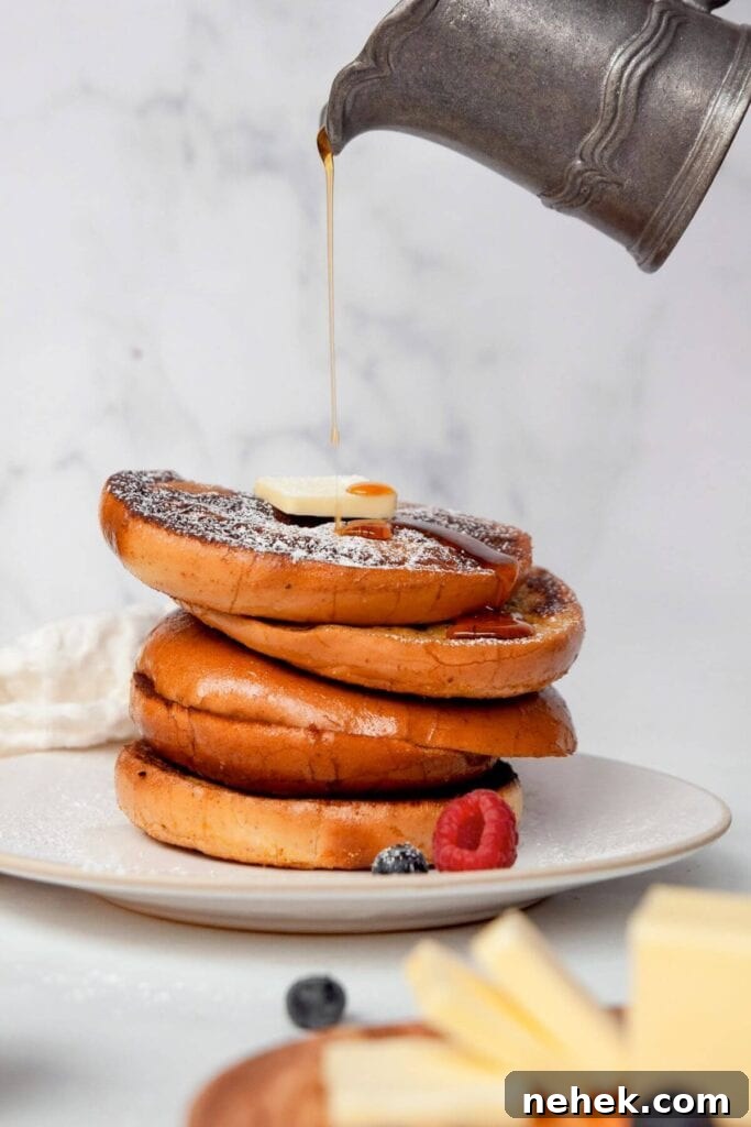 Cinnamon French Toast Bagels with Maple Glaze 3 pouring syrup on top of a stack of french toast bagels
