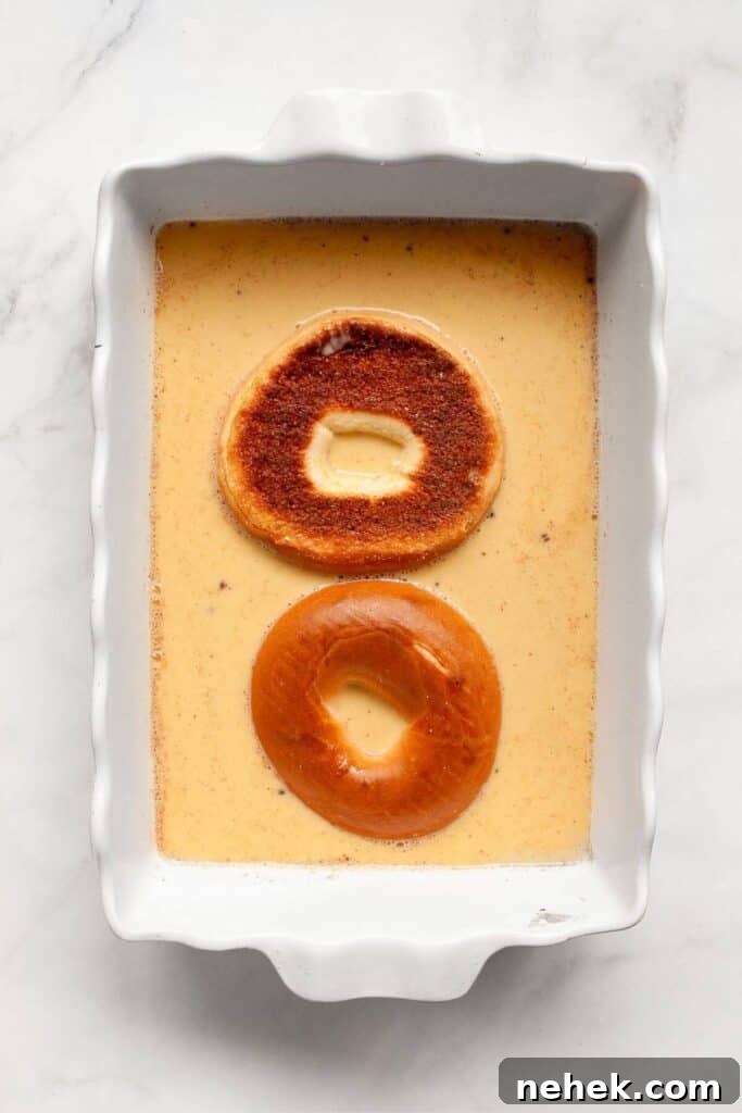 Cinnamon French Toast Bagels with Maple Glaze 5 how to soak a bagel in french toast milk, cinnamon, and egg mixture