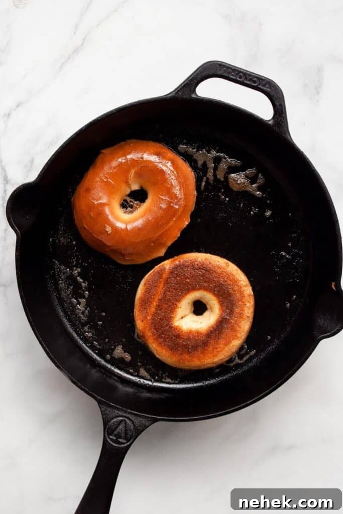 Cinnamon French Toast Bagels with Maple Glaze 6 cooking french toast bagels in a buttery cast iron skillet