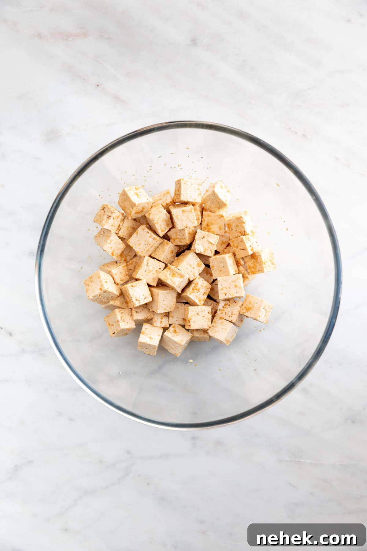 Crispy Oven-Baked Tofu with Golden Crunch 4 Tofu cubes marinating in a large bowl.