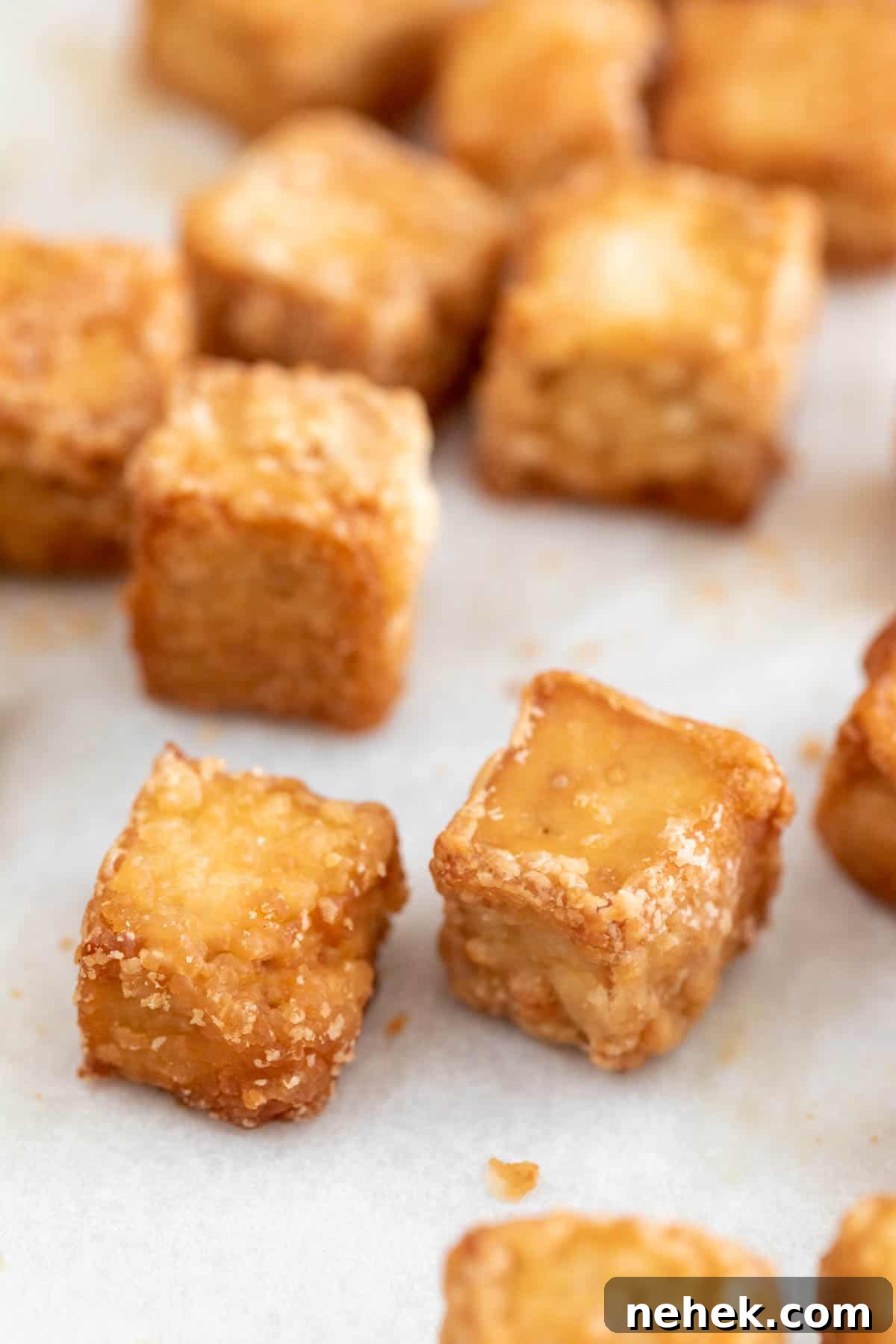 Crispy Oven-Baked Tofu with Golden Crunch 8 Several baked tofu cubes onto a lined baking sheet.
